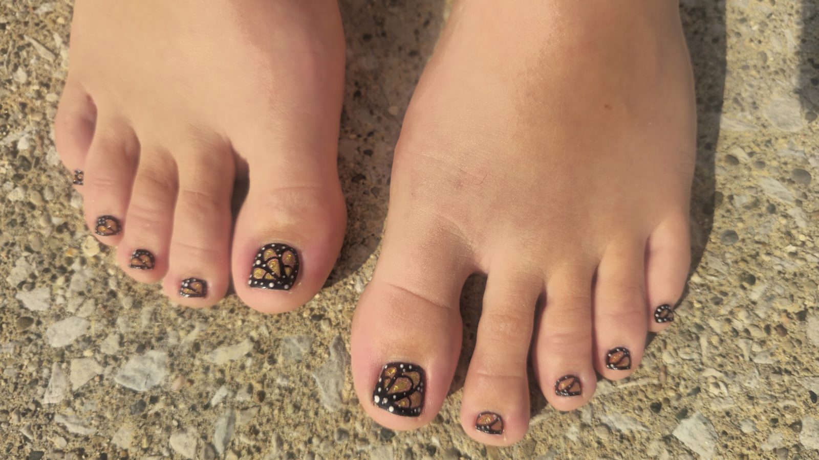 Pedicure with hand-painted monarch butterfly wing designs on every toenail